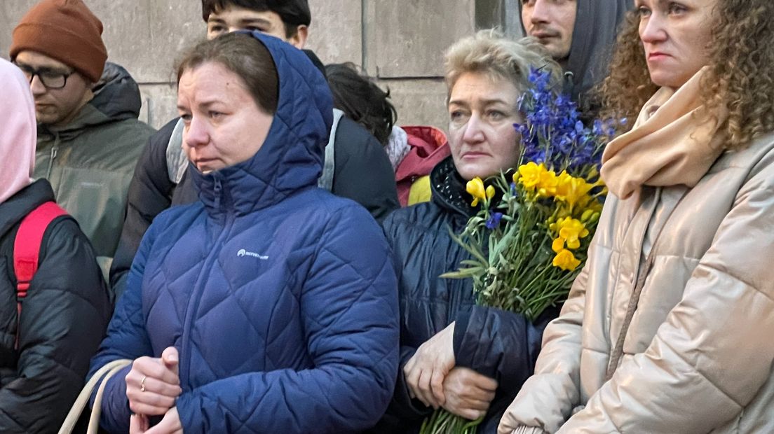 Tatiana IIinykh houdt een bos bloemen in de kleuren van de Oekraïense vlag vast