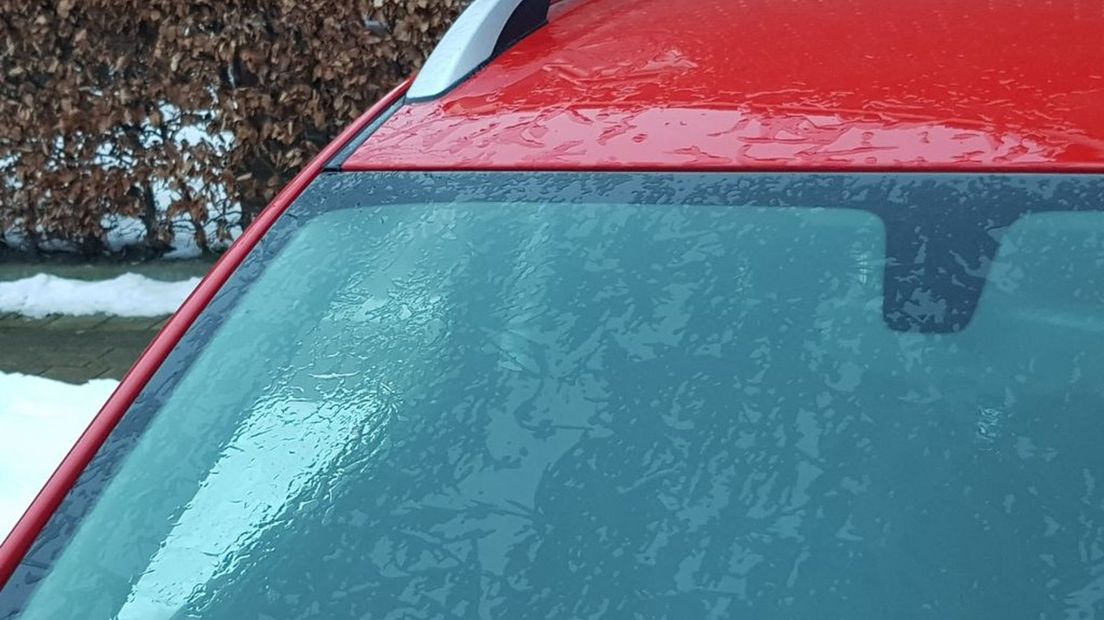 Een auto in Putten zit onder een ijslaag.