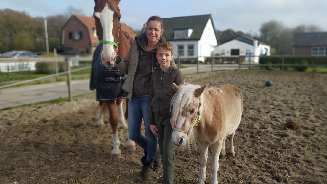 Astrid Duinhoven en haar zoon Tygo bij hun paarden