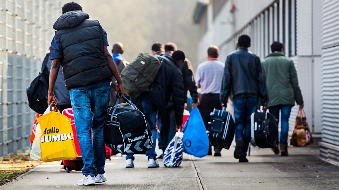 Asielzoekers arriveren bij een asielzoekerscentrum.