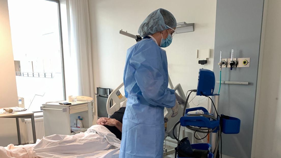 Verpleegkundige helpt coronapatiënt in Saxenburgh Medisch Centrum