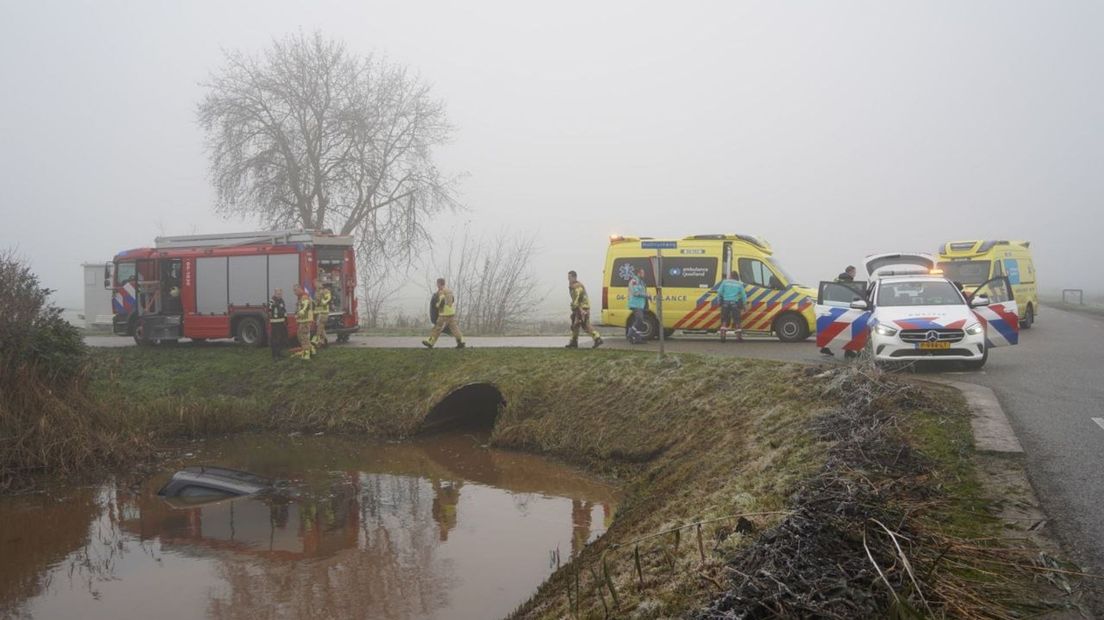 Auto verdwijnt onder water, bestuurder door politieman gered