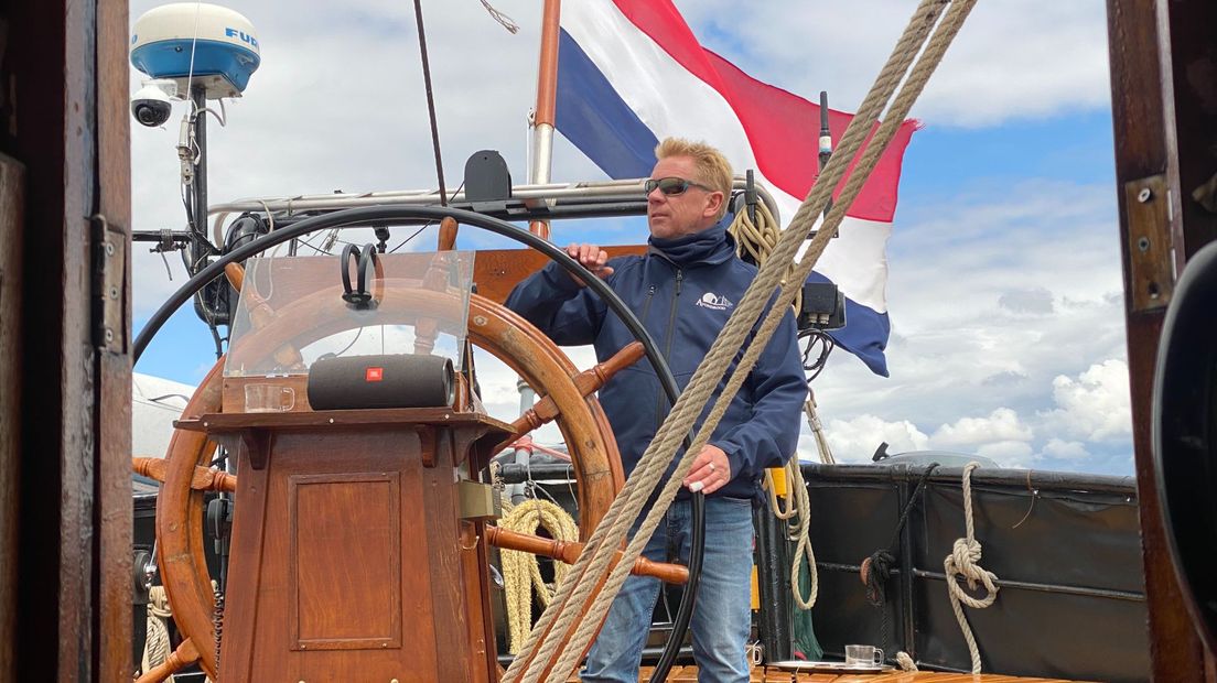 Schipper Rob Peetoom van de klipper Avondrood aan het roer op weg naar Urk