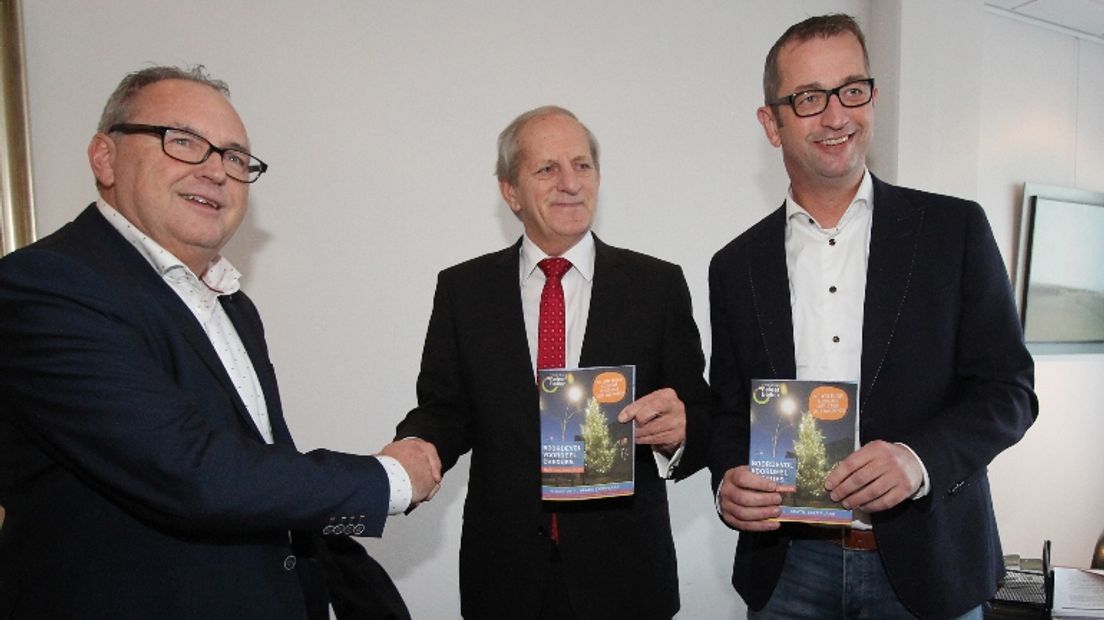 Ton Baas (midden) met het eerste exemplaar van de Beleef Beilen-gids (Rechten: RTV Drenthe/Robbert Oosting)