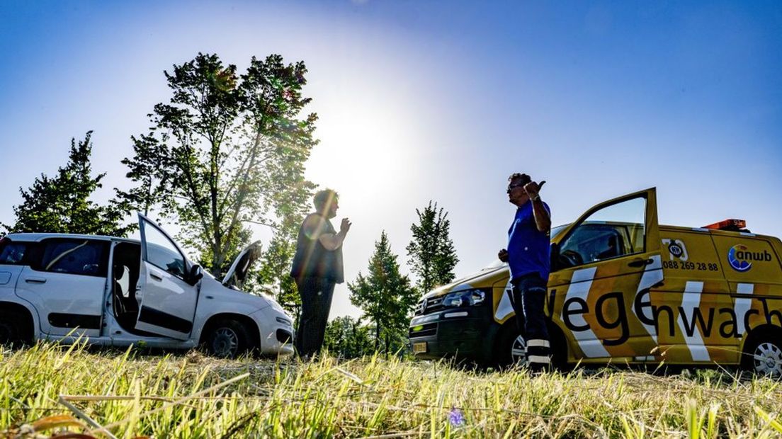 Een wegenwacht helpt een auto met pech langs de weg