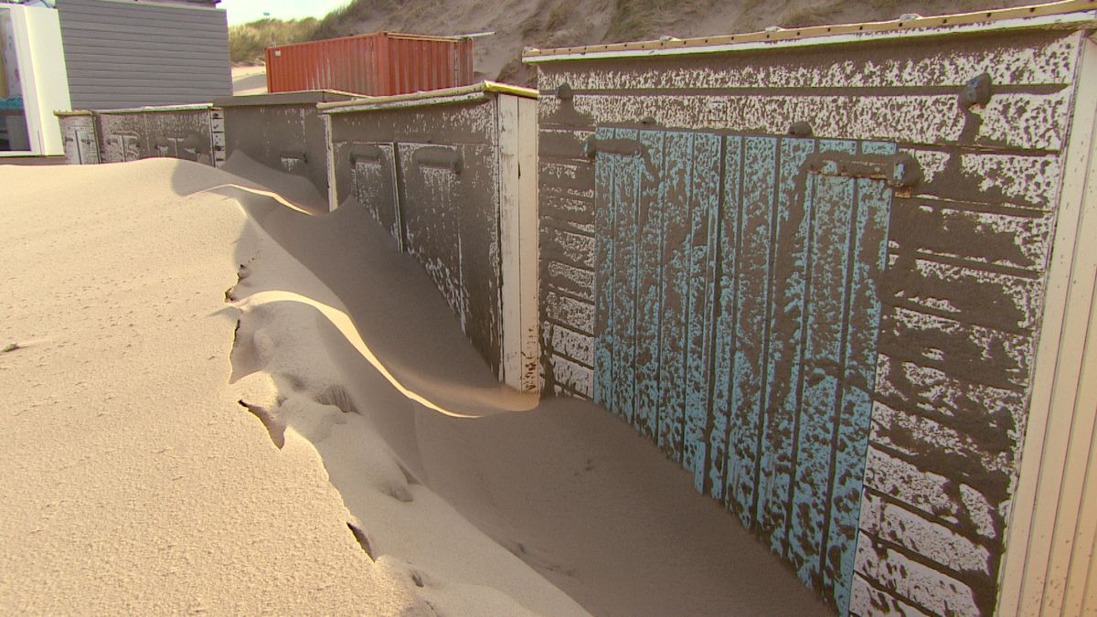 Zand ligt meters hoog tegen de strandhokjes in Domburg en Oostkapelle