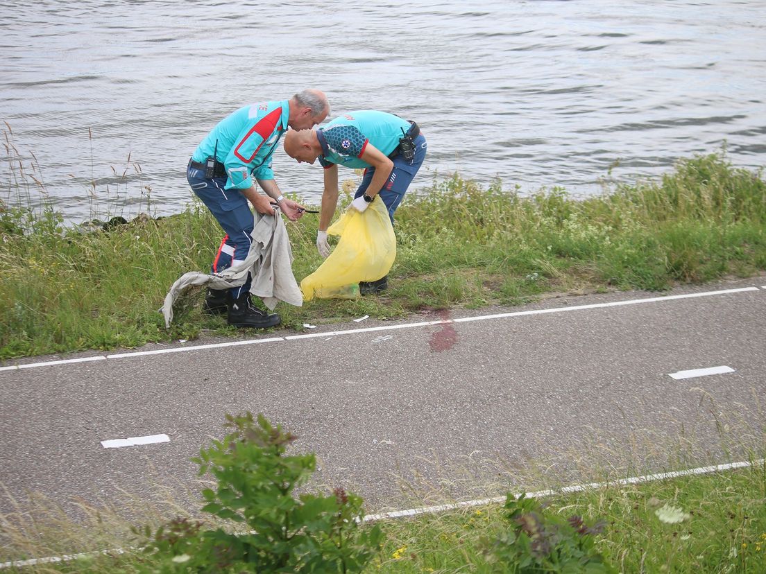 Hulpverleners maken de Rivierdijk na de dramatische botsing schoon