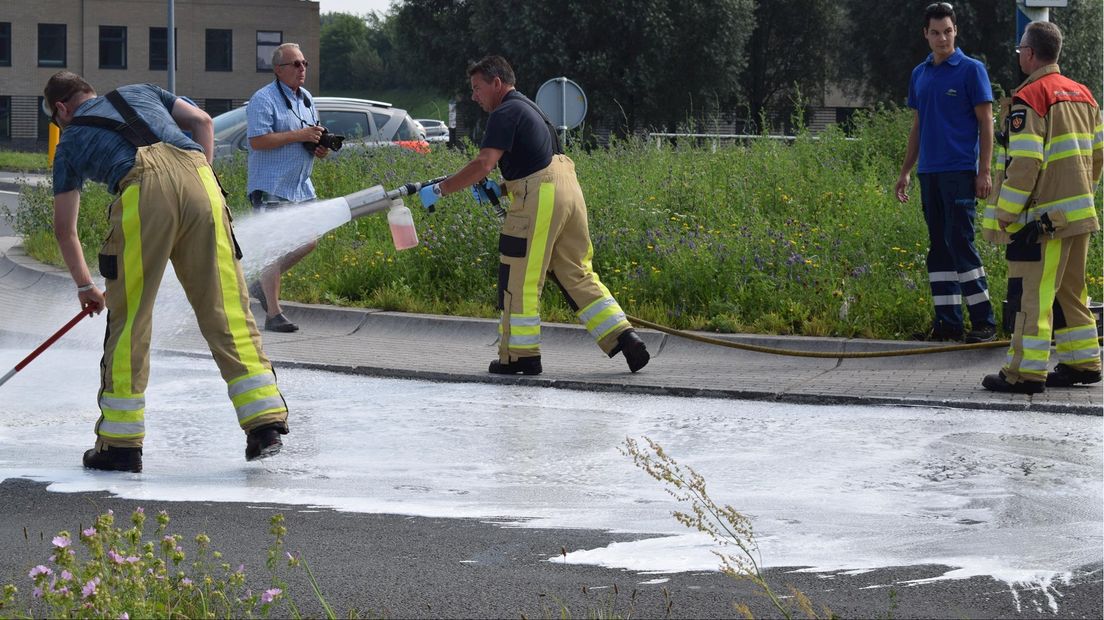 Brandweer schrobt met hydraulische vloeistof besmette rotonde schoon
