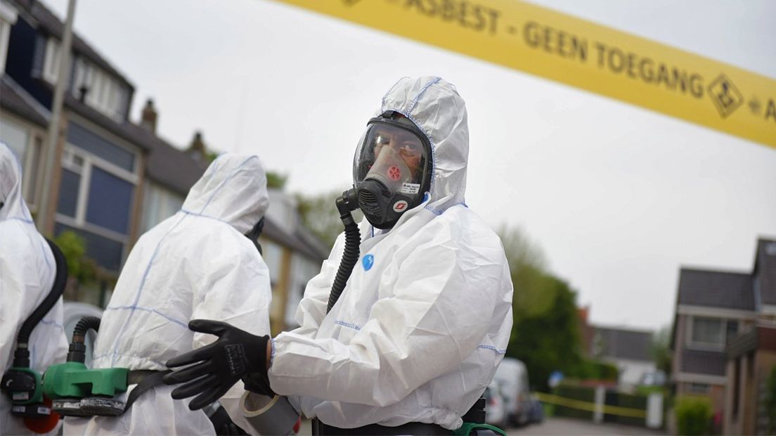 Mannen in witte pakken verwijderen asbest na de brand in Hazerswoude-Dorp. 