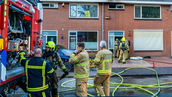 Buren pakken tuinslang om uitslaande brand te blussen