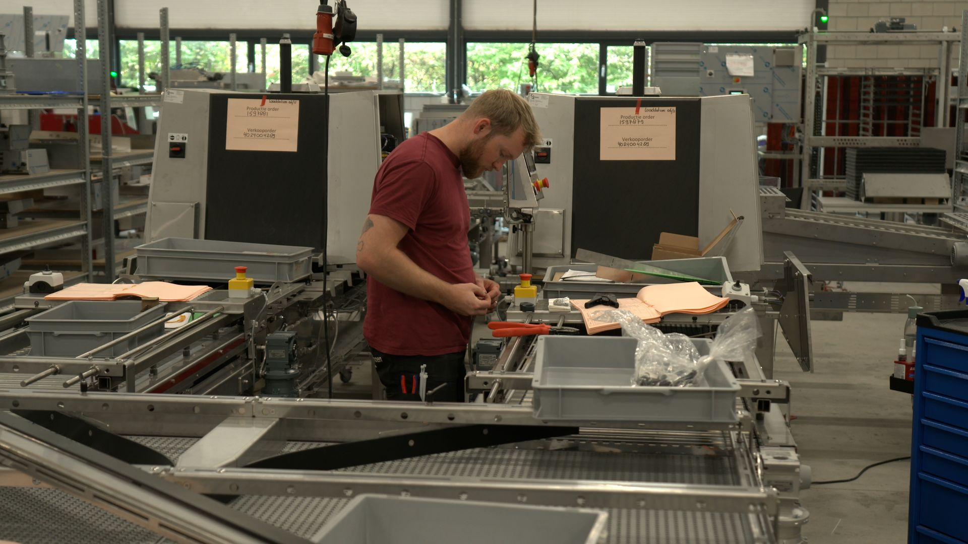 Een werknemer zet een sorteermachine in elkaar