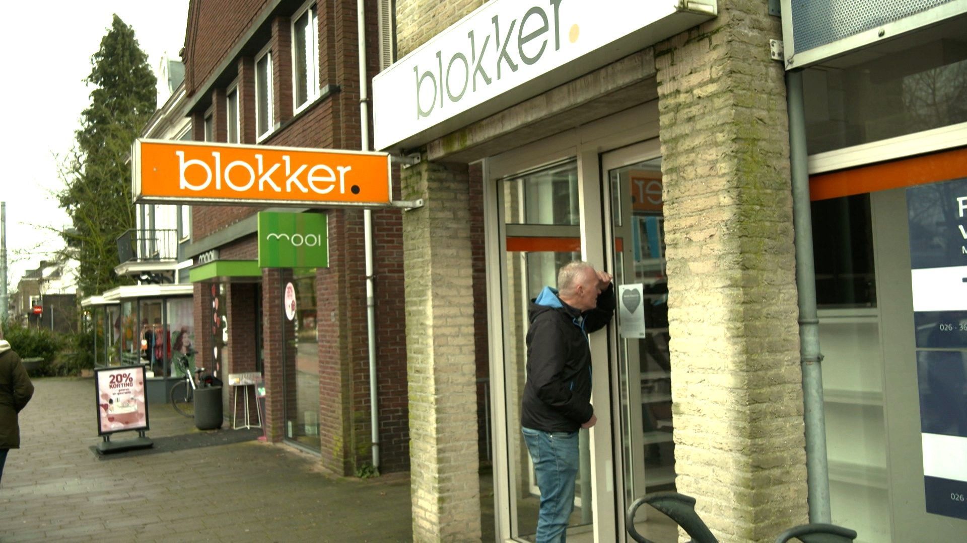 Retaildeskundige Cor Molenaar tuurt door de ruit van de gesloten Blokker in Oosterbeek.