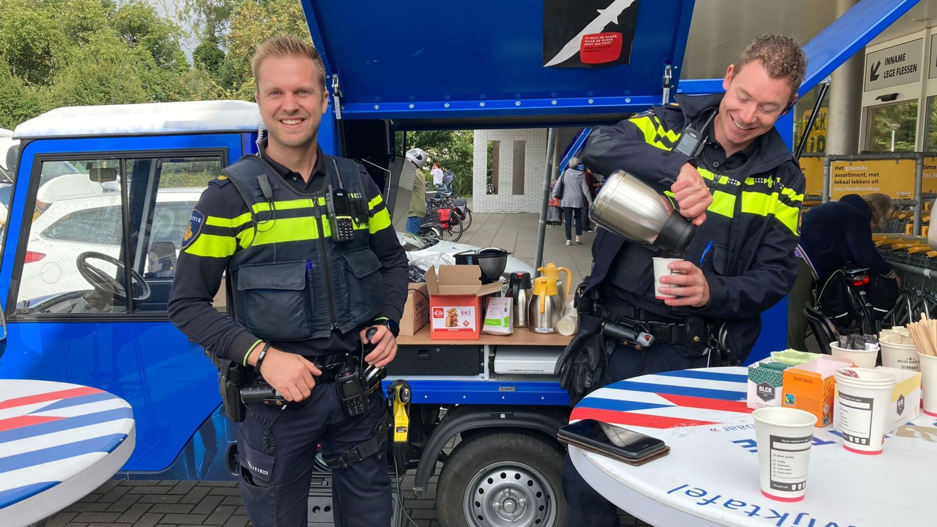 Wijkagenten Maikel Boomkamp en Tjerk Sprenkelder naast de politie-tuktuk in Aalten