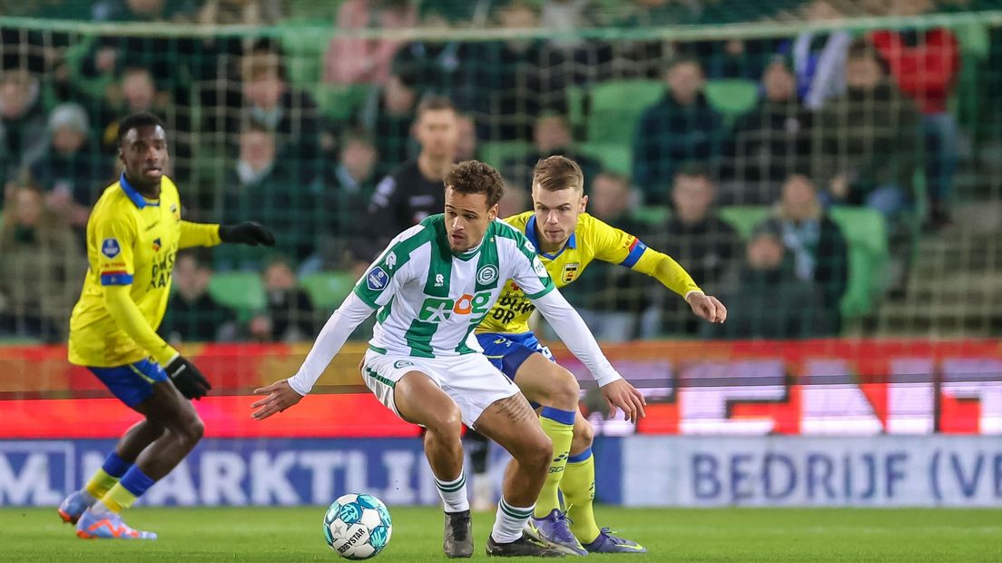 Liam van Gelderen houdt namens FC Groningen tegenstander Jamie Jacobs van zich af