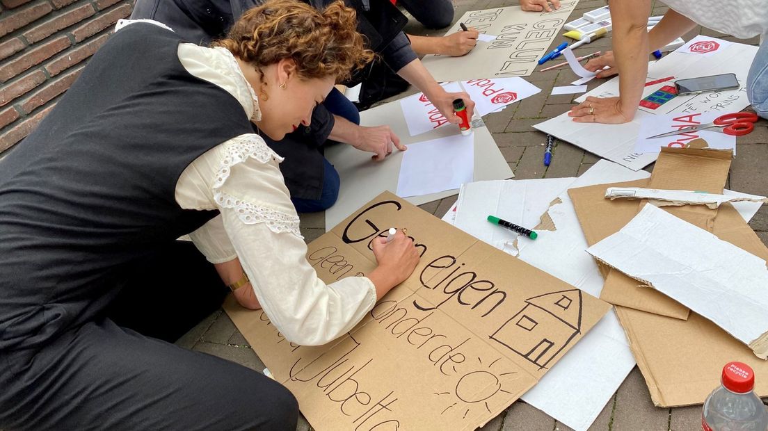 Lokale PvdA-leden maken protestborden voor het woonprotest in Amsterdam.