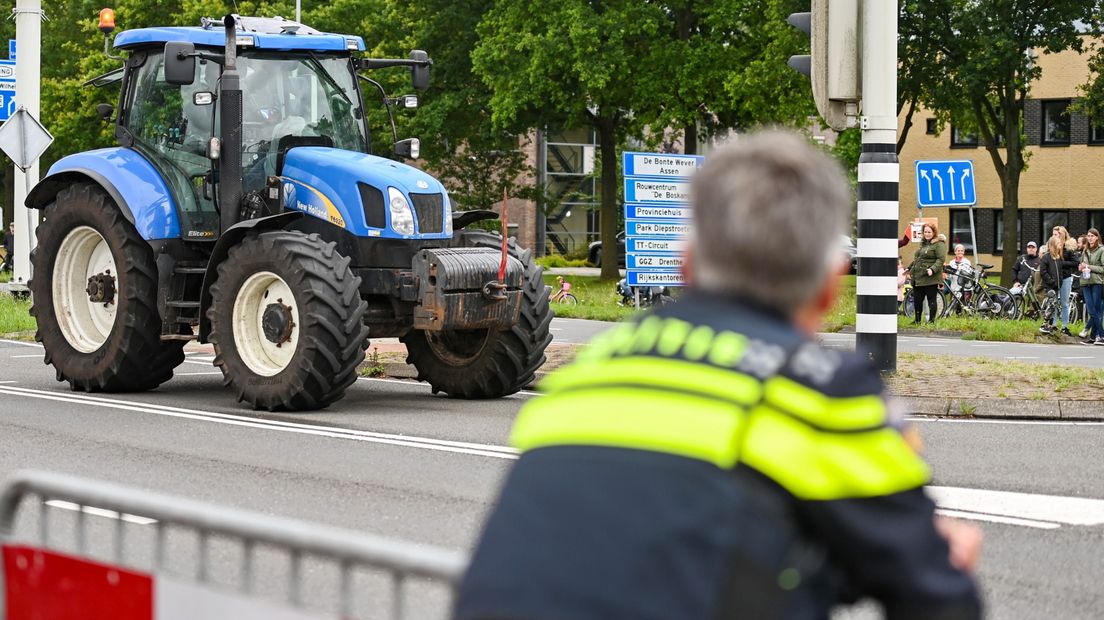 Een trekker rijdt langs een politieagent tijdens een eerder boerenprotest