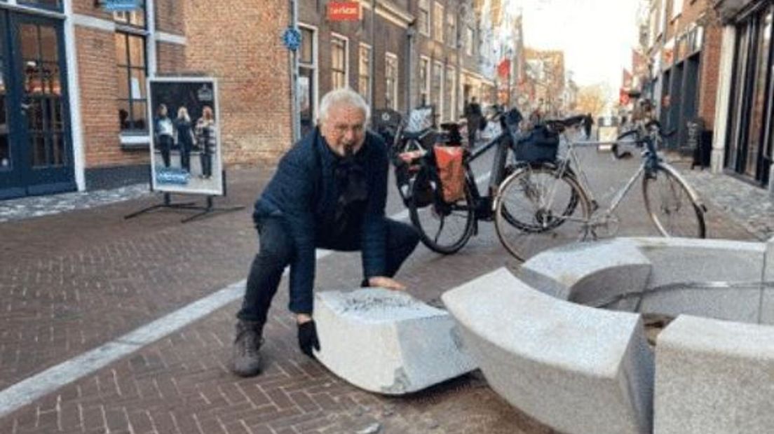 Havinga probeert de vernielde plantenbak op te ruimen.