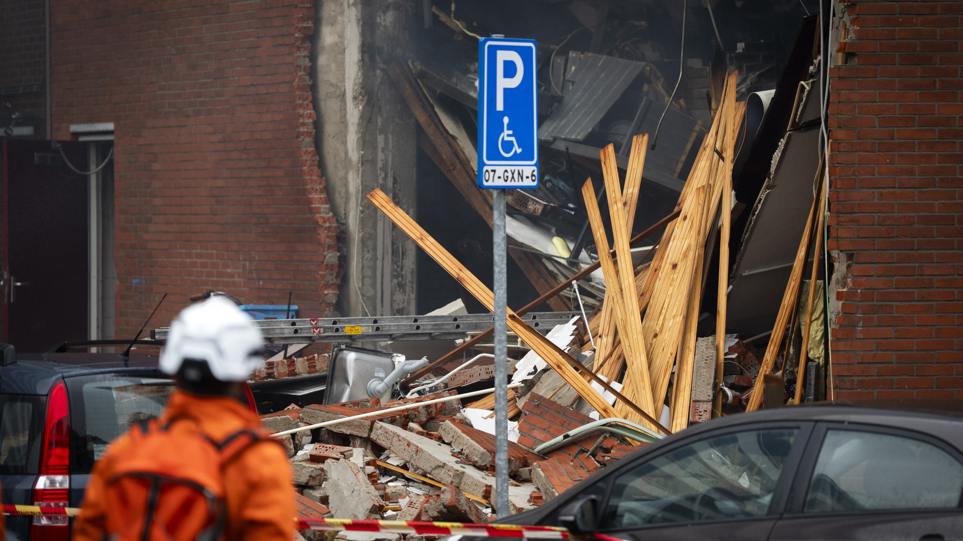 Een lid van het STH-team kijkt naar de ravage na de explosie aan de Osdorper Ban in Amsterdam
