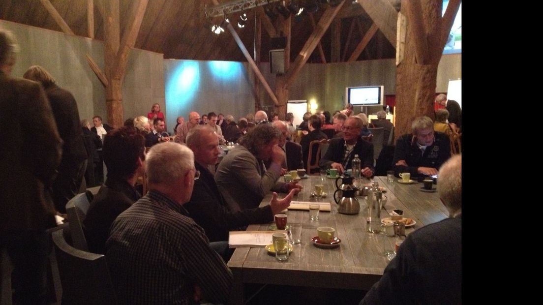 Gemeenteraden en burgemeesters praten met elkaar tijdens een bijeenkomst in Huizinge.