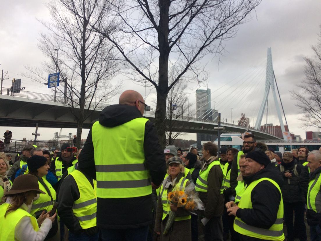 Jan Dijkgraaf (op de rug) spreekt de gele hesjes toe bij de Erasmusbrug