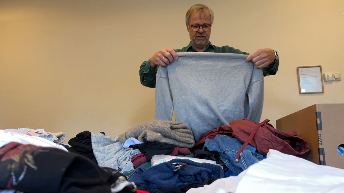 Kerkmeester Jan sorteert gedoneerde kleding