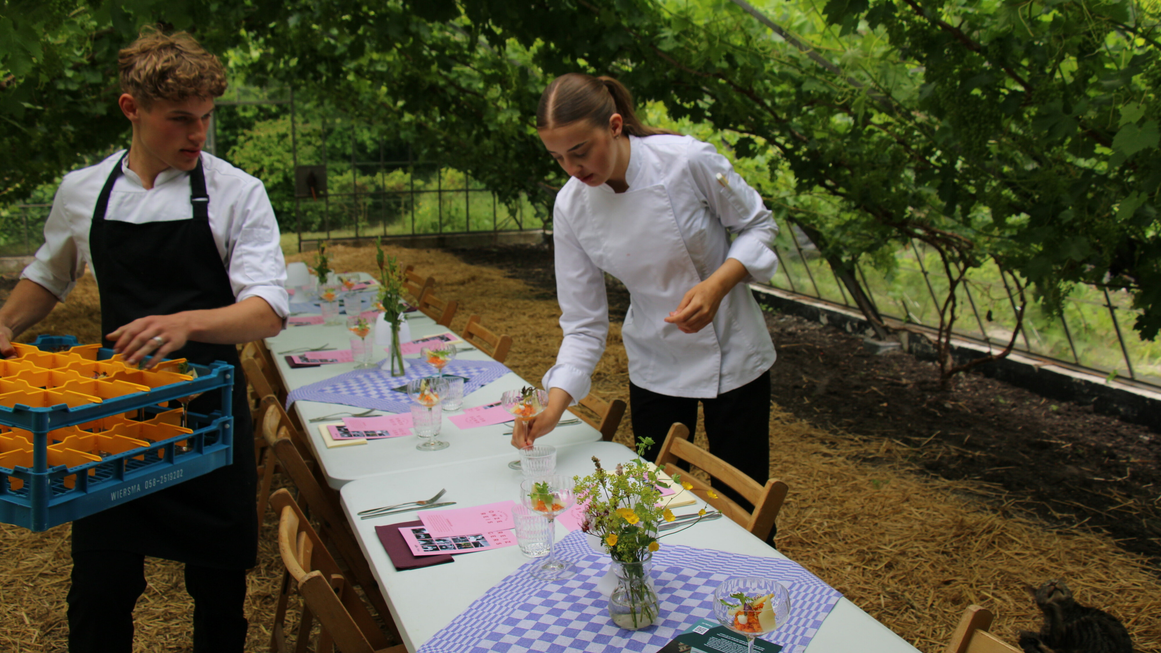 Studenten zetten de gerechten voor de high tea op tafel