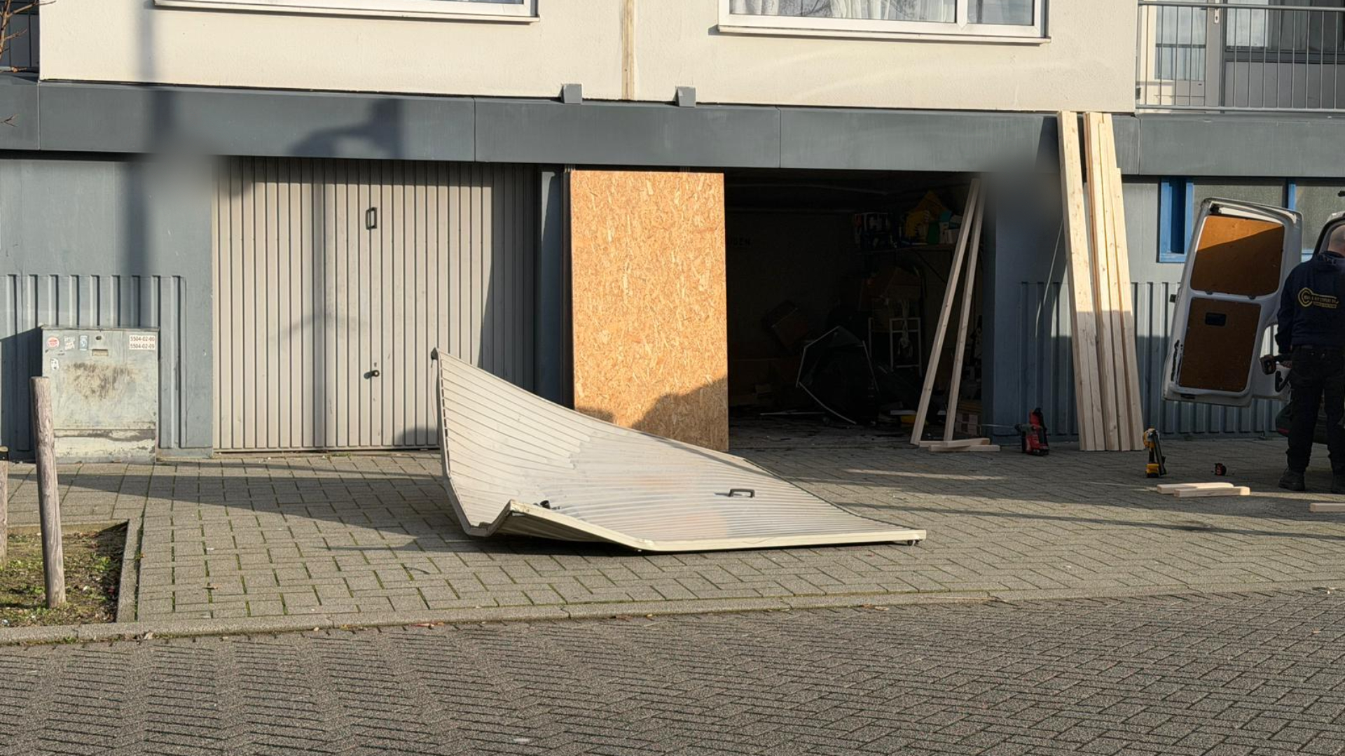 De omvergereden garagedeur.