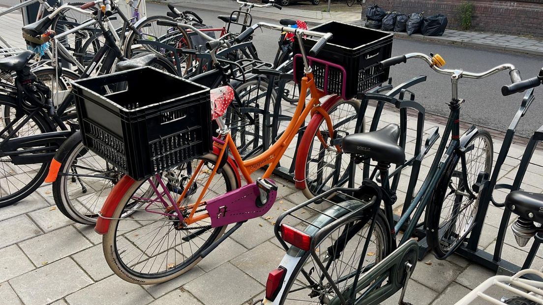De felgekleurde fiets met kratten in de fietsenstalling aan de Oudwijkerdwarsstraat