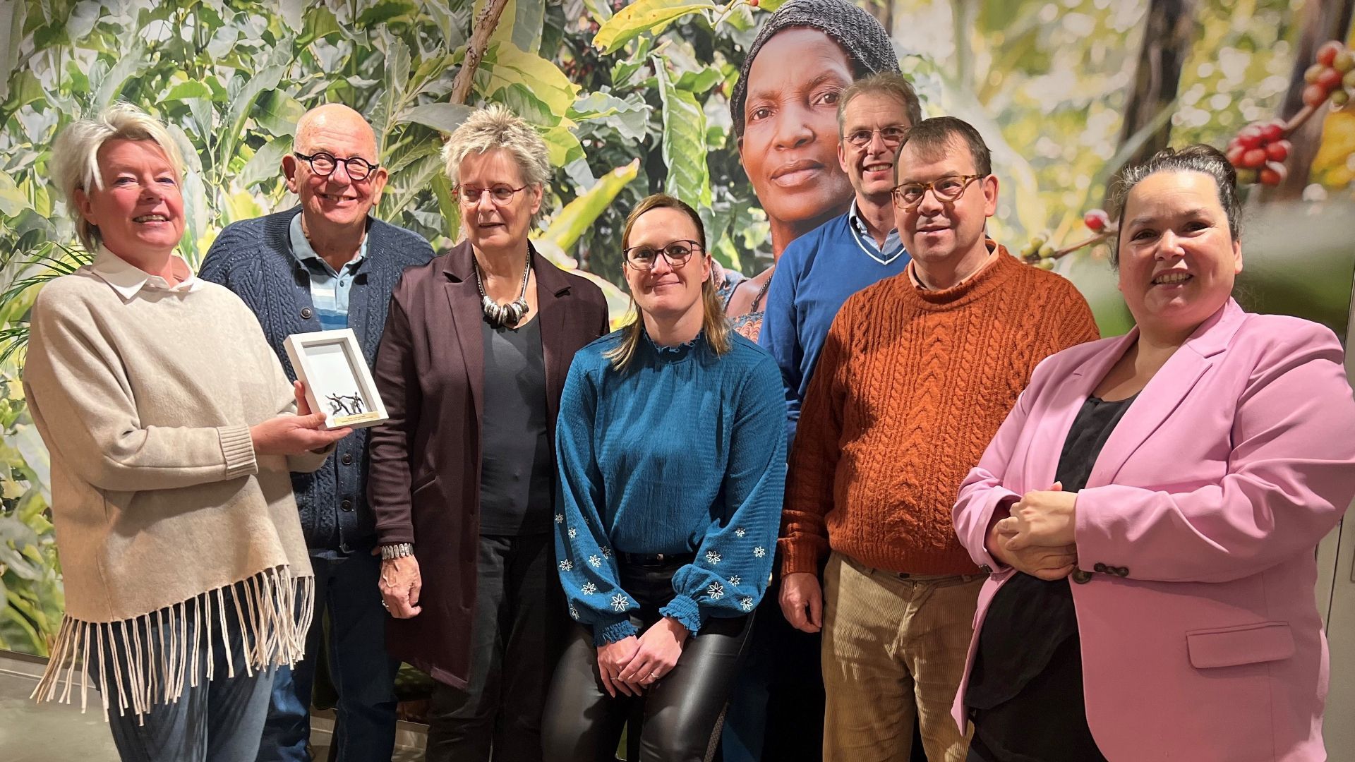 Ans Kobus met medewerkers, wethouder Schepers (r) en bestuursleden WUh onder toeziend oog van Betty Kalimi.