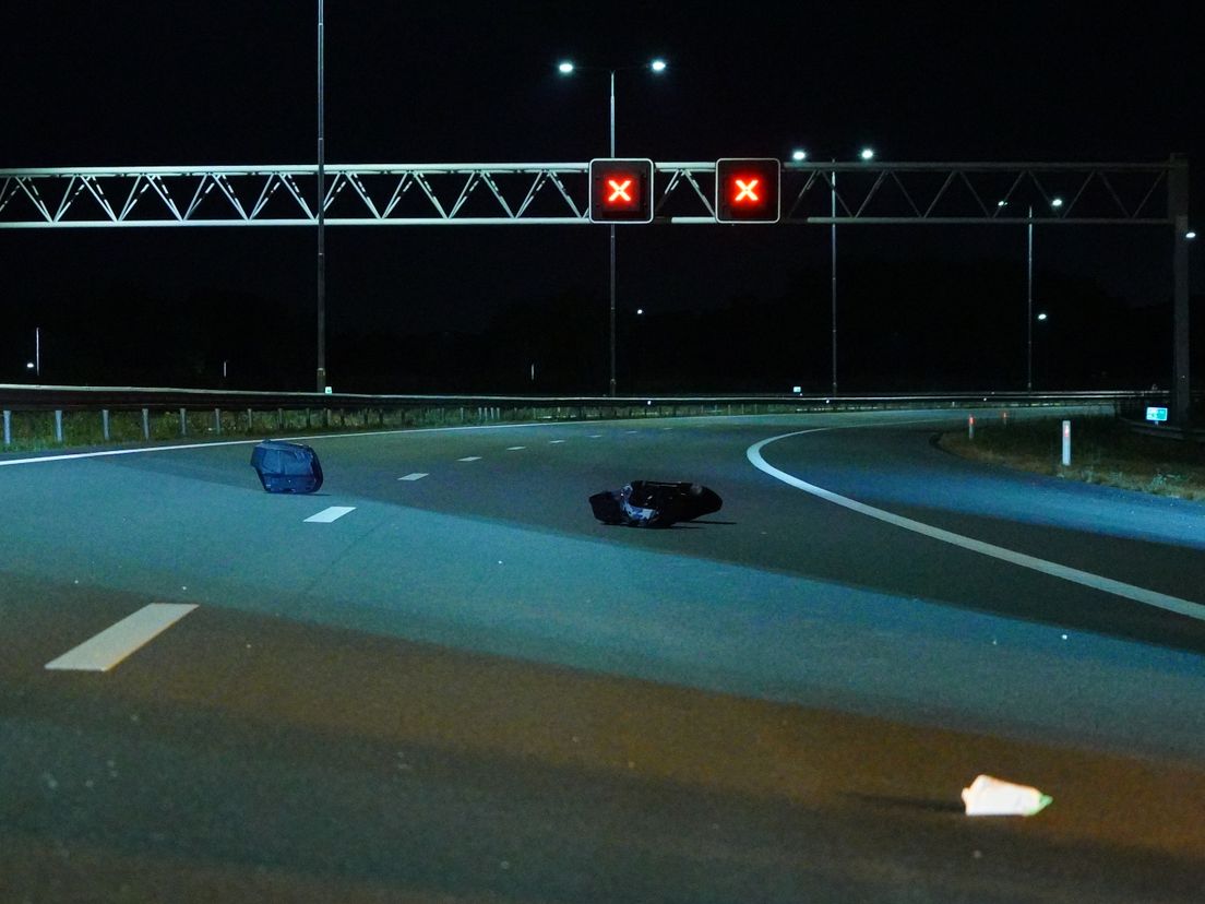 Brokstukken liggen verspreid op de weg.