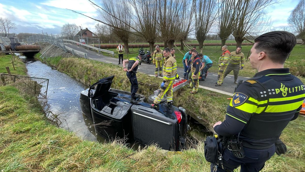 Auto rijdt van de weg en belandt op zijkant in sloot