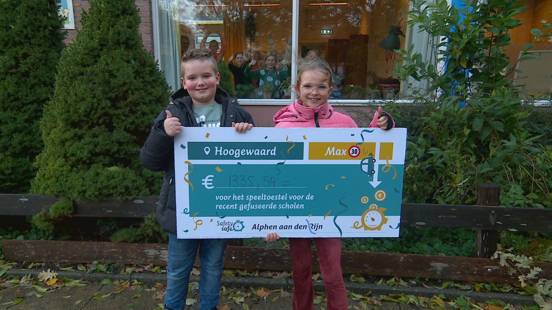 Nora (rechts) en Dex tonen een cheque met de opbrengst