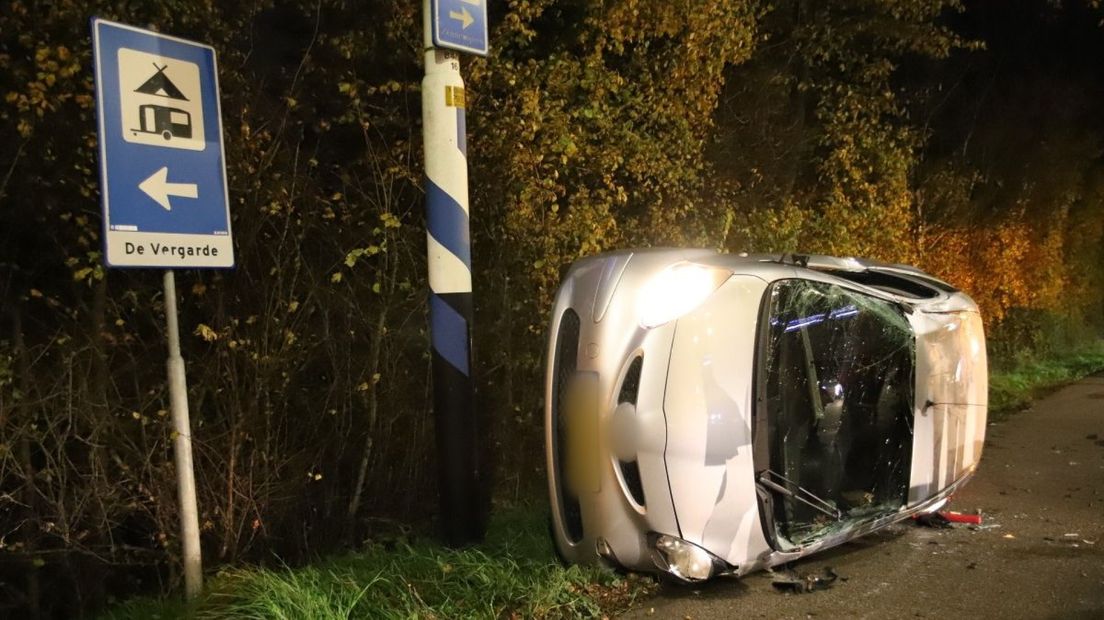 Auto botst tegen stoplicht en komt op zijn zijkant terecht.