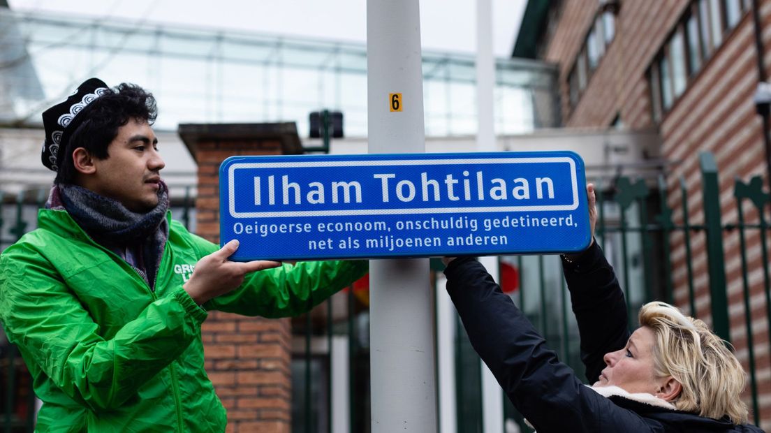 Alerk Ablikim (links) en GroenLinks-lijsttrekker Mariëlle Vavier hangen het straatnaambordje op