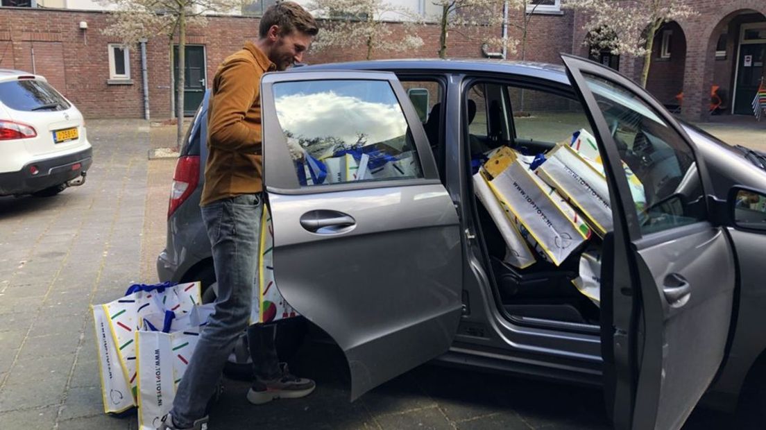 Lars Duistermaat zet de tassen in een auto voor vervoer naar de Voedselbank.