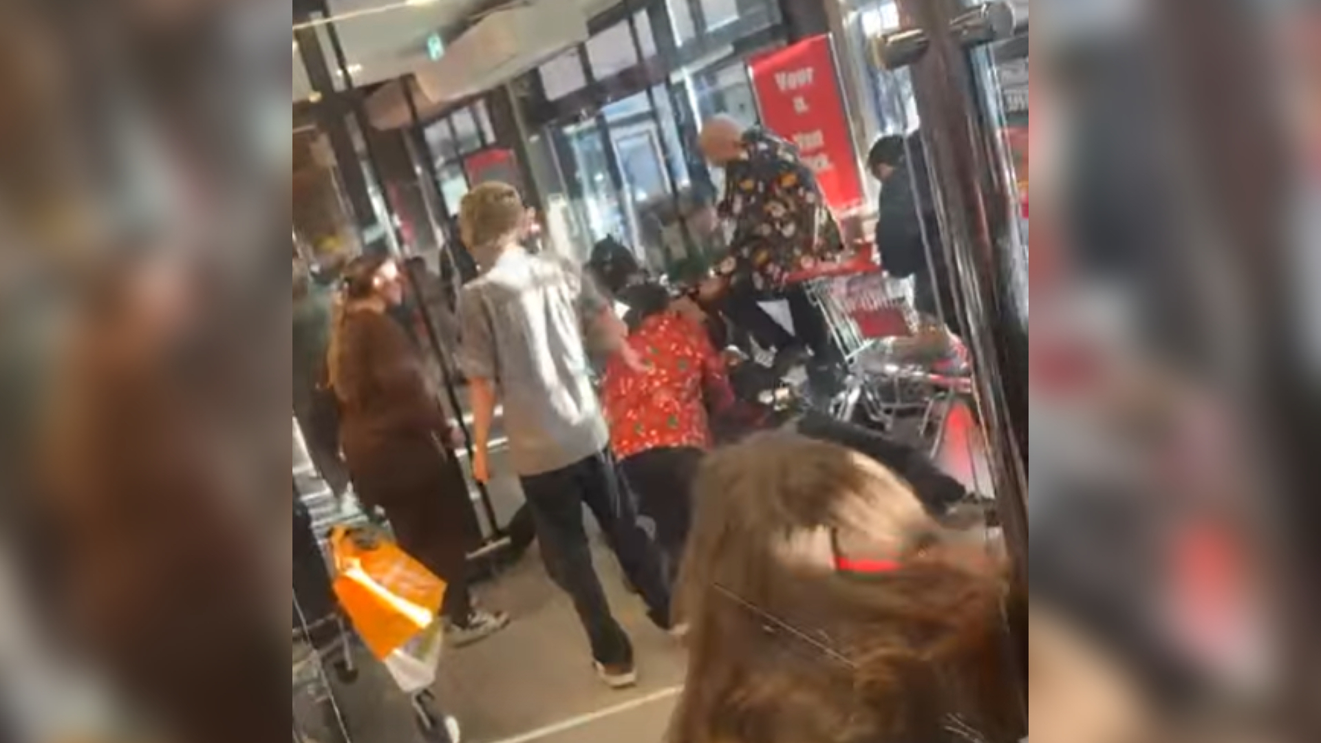 In de video is te zien dat een winkelmedewerker iemand schopt die op de grond ligt.