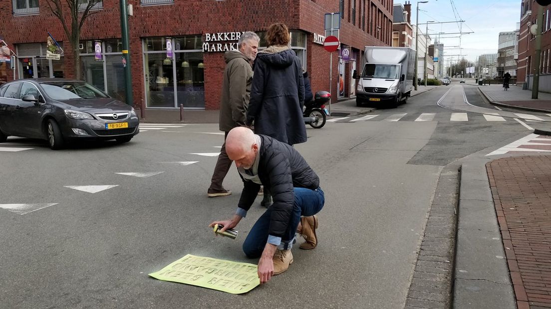 De Haagse Stadspartij spoot maandag leuzen tegen sluipverkeer op straat in de Stationsbuurt. | Foto Omroep West