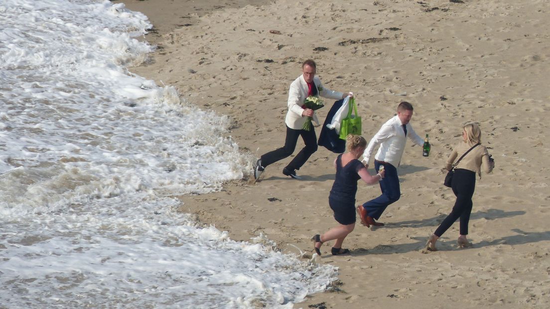 Bruidspaar wordt verrast door een golf op het badstrand van Vlissingen