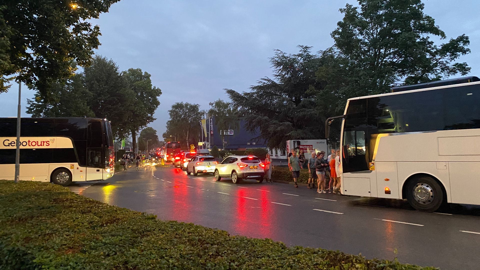 Touringcars komen van verschillende kanten om mensen op te halen.