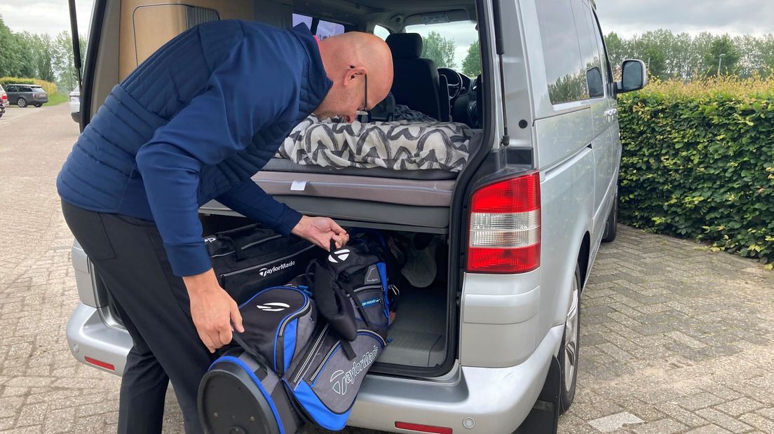 Hans Wognum pakt zijn golfclubs uit de auto.