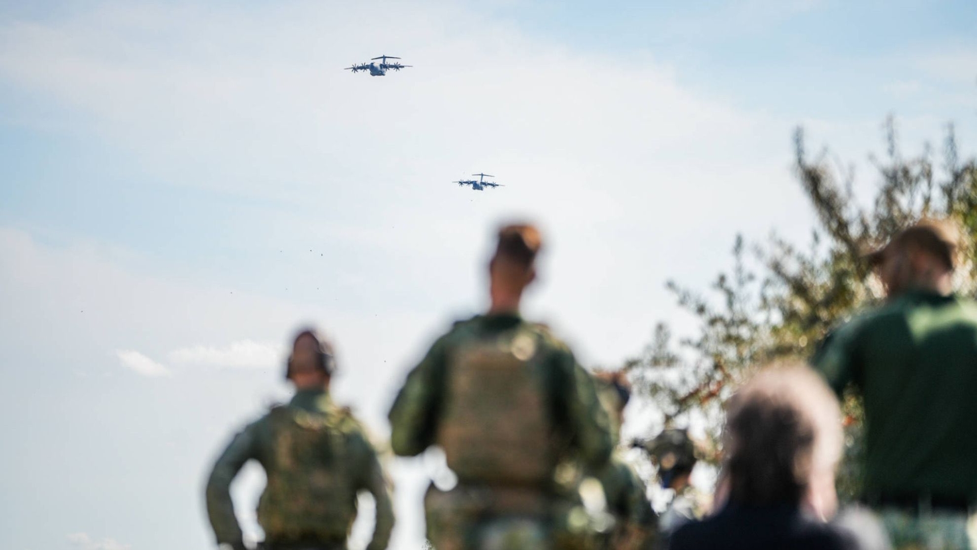 Militairen kijken naar transportvliegtuigen in lucht