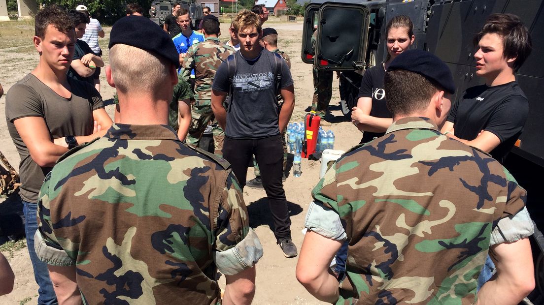 Mariniers geven jongeren uitleg over hun werk.