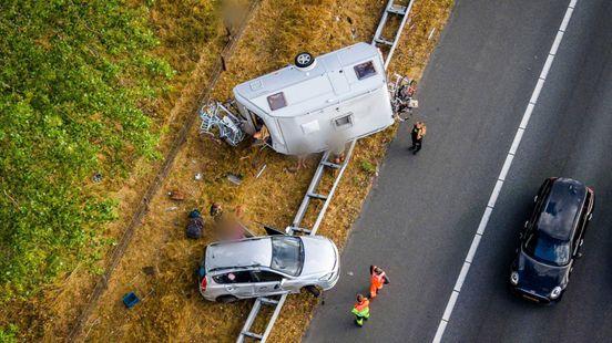 Auto en caravan belanden op vangrail