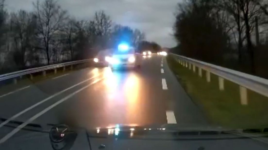 De bestuurder van deze auto ziet een politiewagen, op weg naar een spoedgeval, recht op zich afkomen.