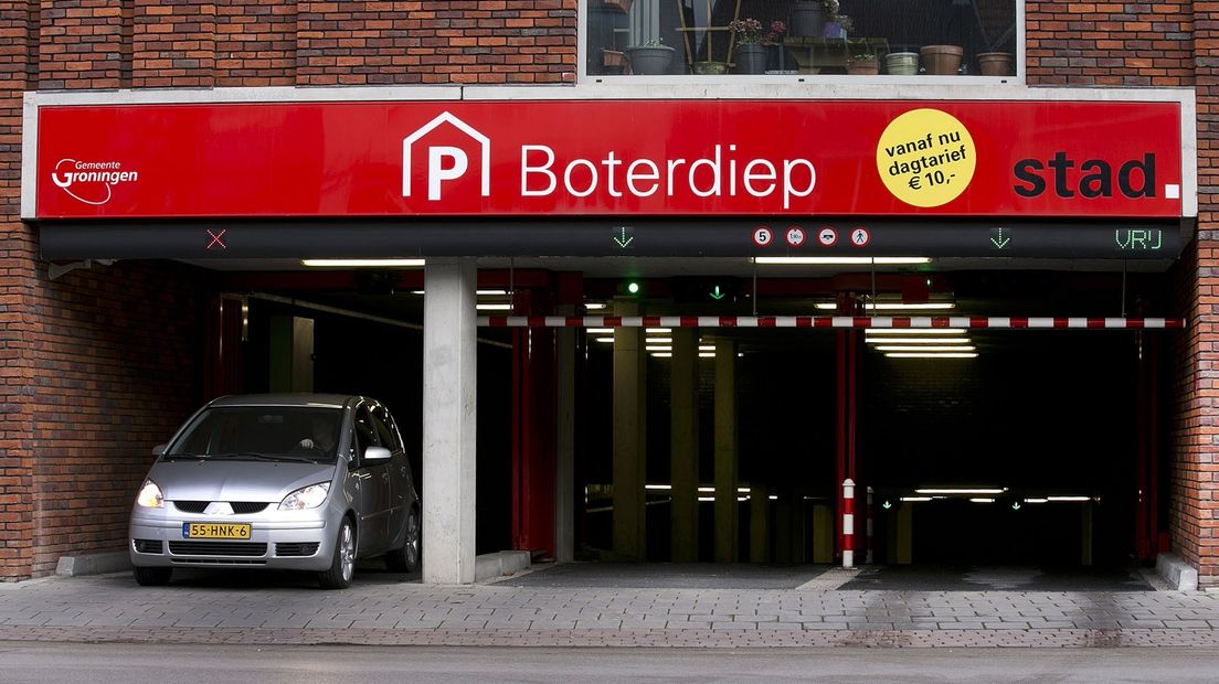 Een auto verlaat een parkeergarage in Stad