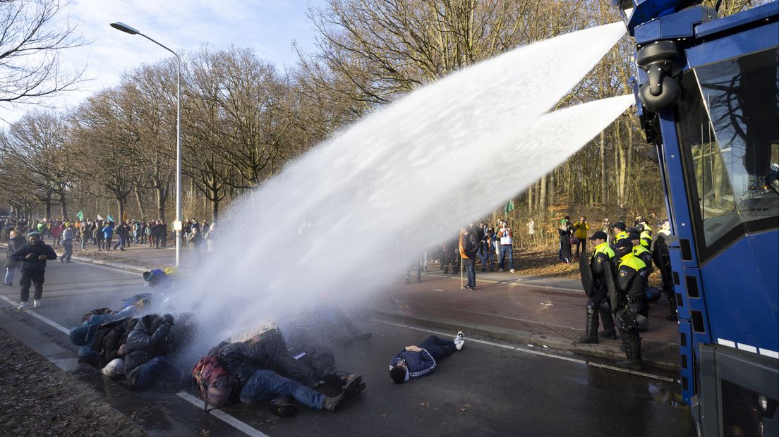 Het waterkanon spuit demonstranten nat op de A12