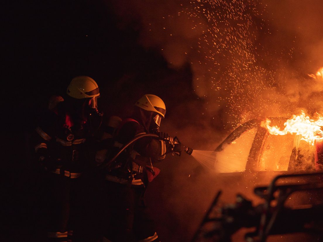 Brandweermannen blussen een vuurzee in een auto (Foto ter illustratie)