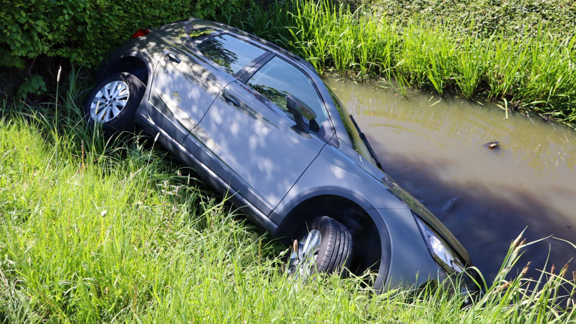 De auto lag op z'n zijkant in het water.