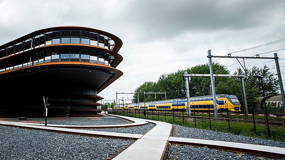 Een trein rijdt langs het nieuwe kantoor van ProRail in Utrecht.