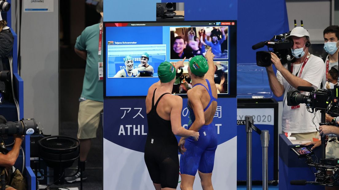 Schoenmaker (rechts) en landgenote Kaylene Corbett begroeten vrienden en familie via een webcam